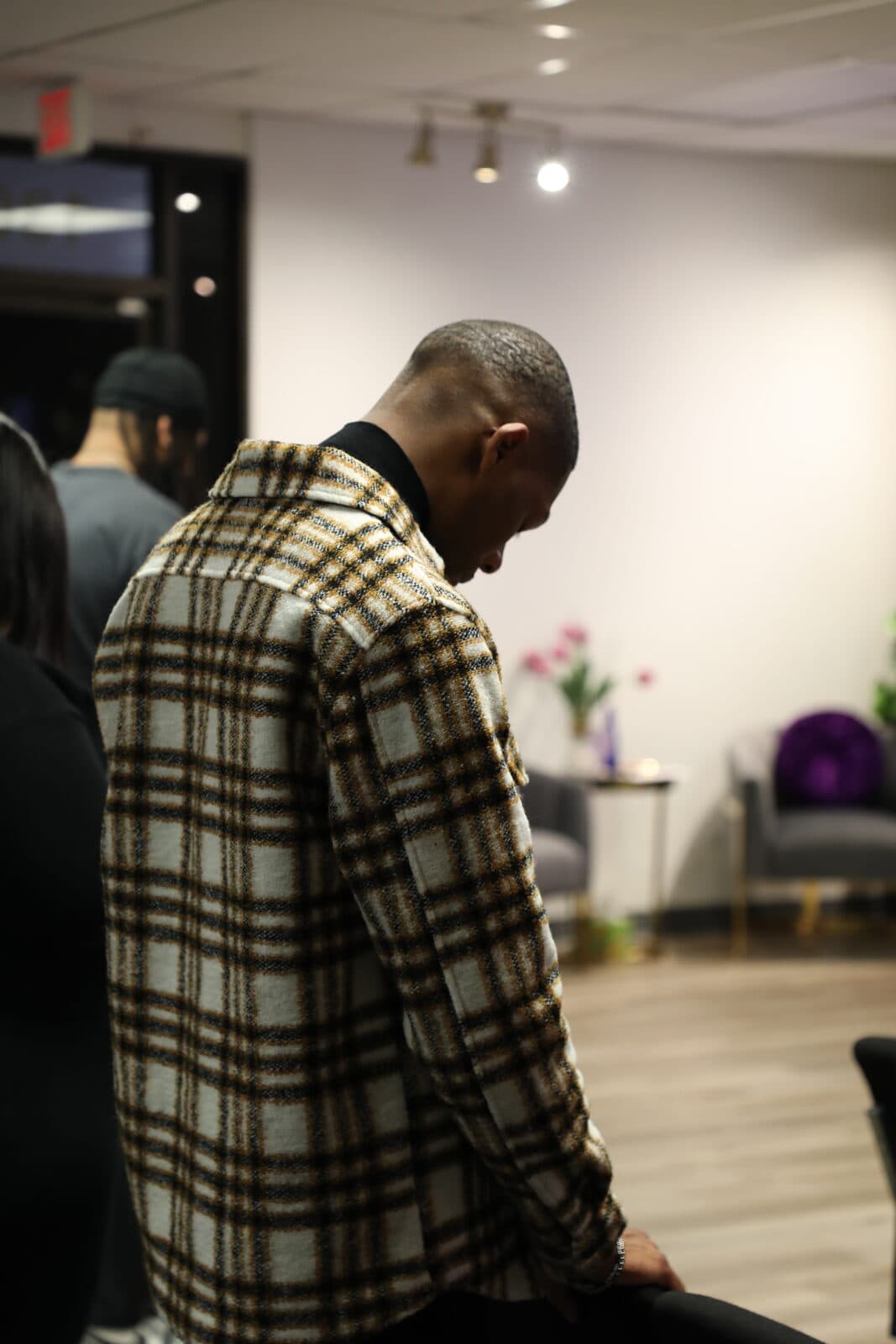 A man standing with his head bowed in prayer