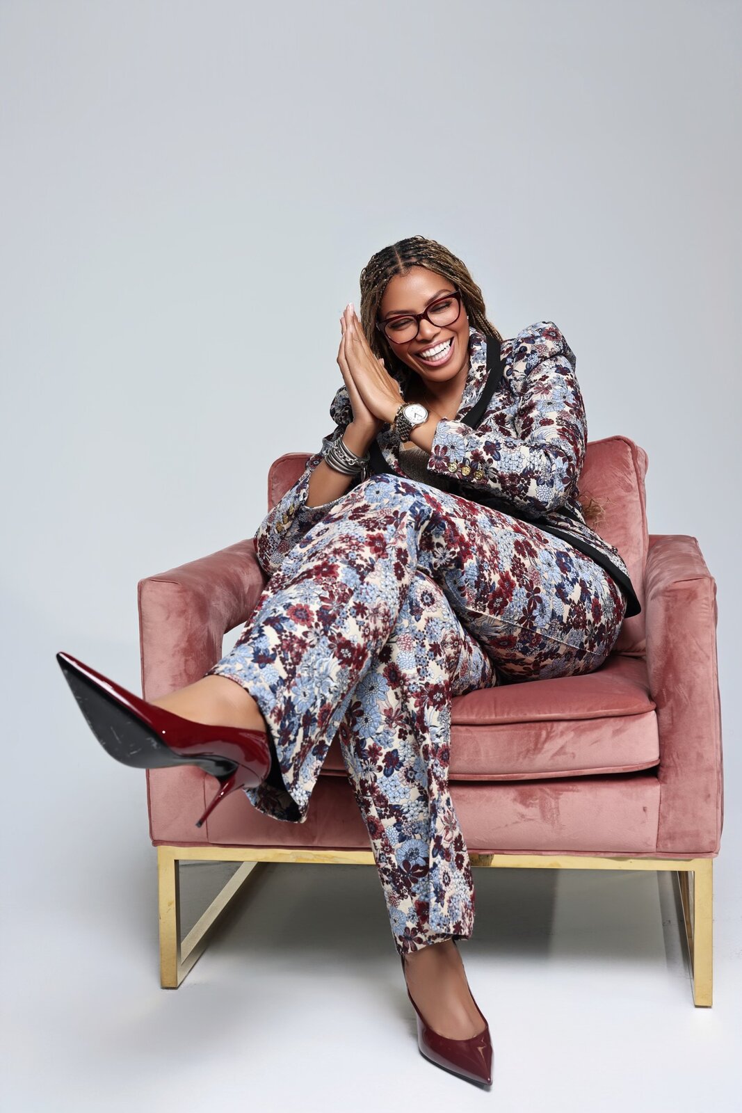 Pastor Yorie Gipson seated on a pink velvet chair, hand to her face